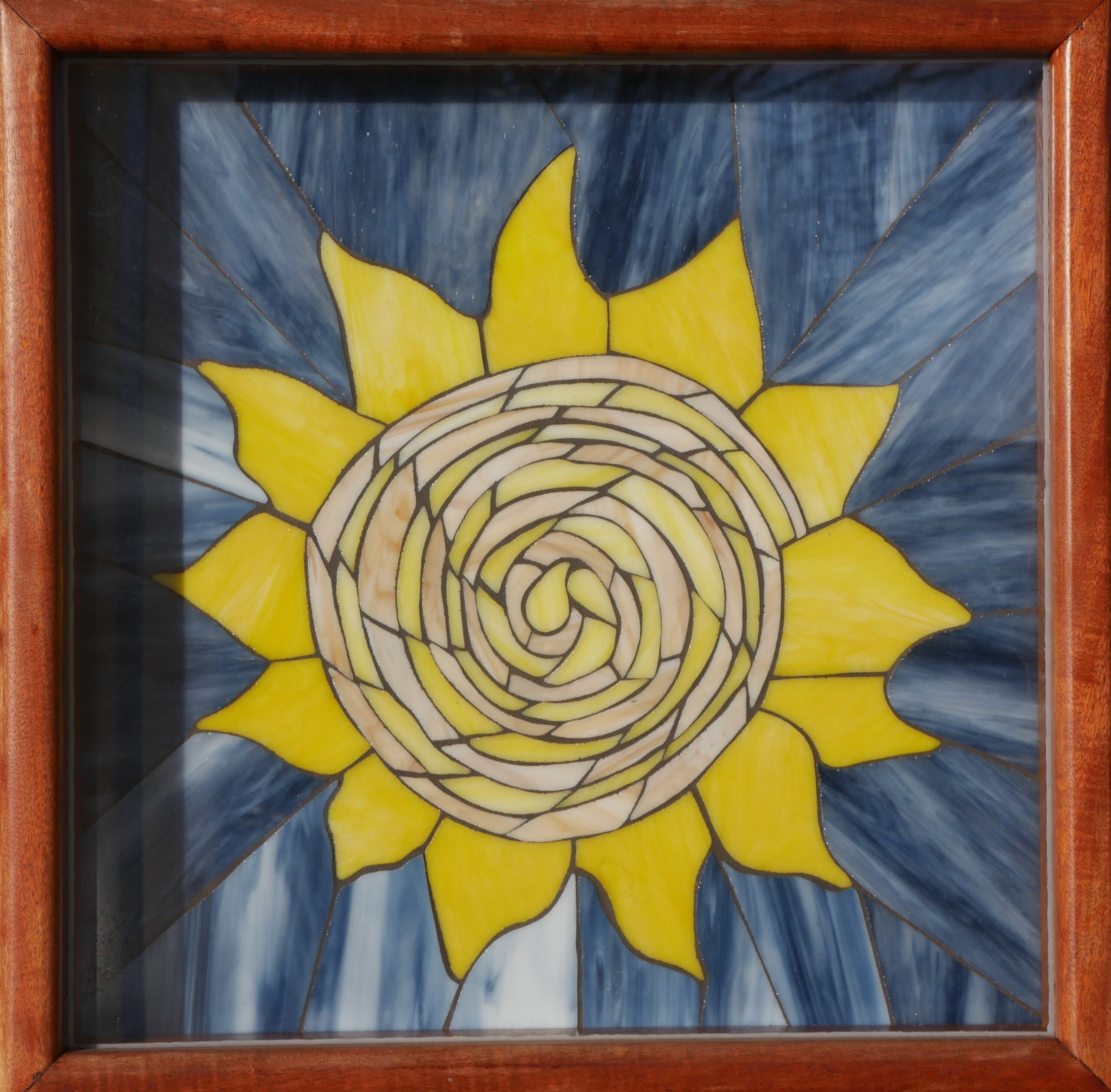 A glass portrait of the Enola Group sun 